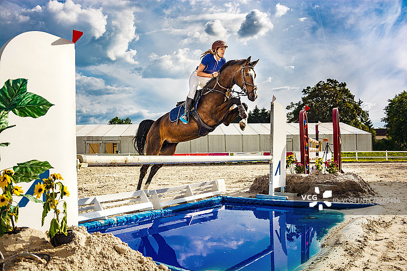 场地障碍赛：骑手与马跳跃障碍图片素材