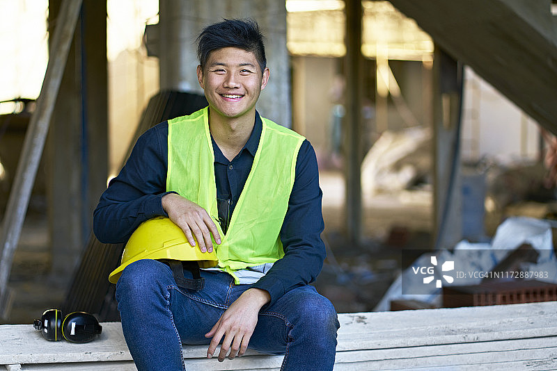 笑容满面的年轻建筑承包商坐在木板上图片素材