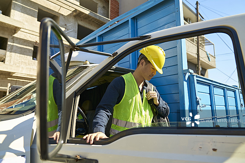 从卡车上下来的男性建筑工人图片素材