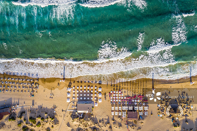 夏季沙滩上拥挤的太阳伞和人群的对称鸟瞰图图片素材
