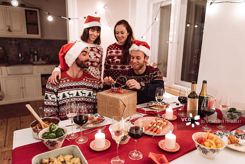 朋友们在圣诞晚宴上打开礼物图片素材
