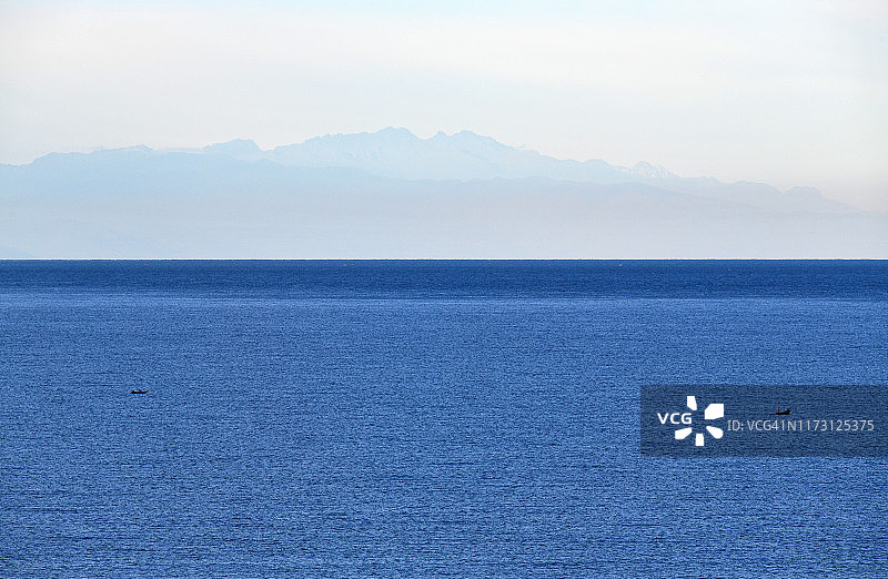 艾伯特湖碧绿湖岸与远处的鲁文佐里山脉图片素材