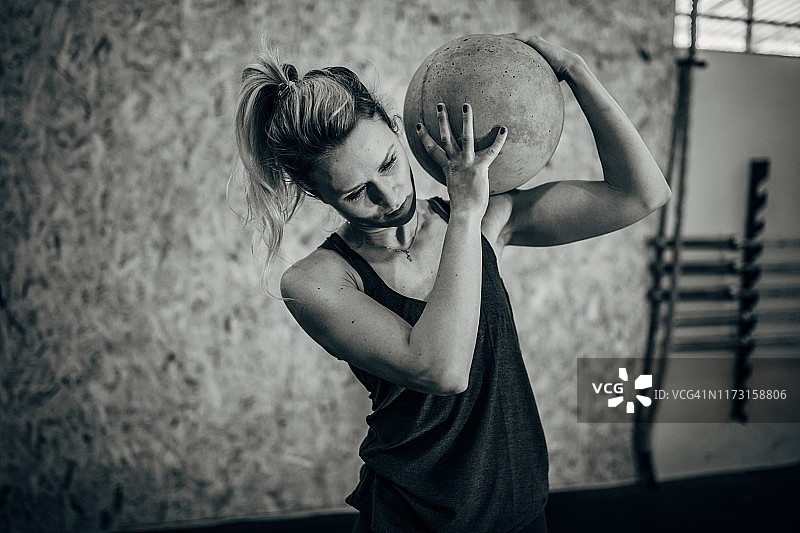 健身女人用混凝土球锻炼图片素材