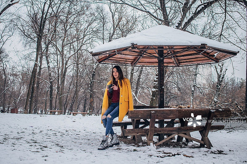 在公园里拿着相机的年轻女人图片素材