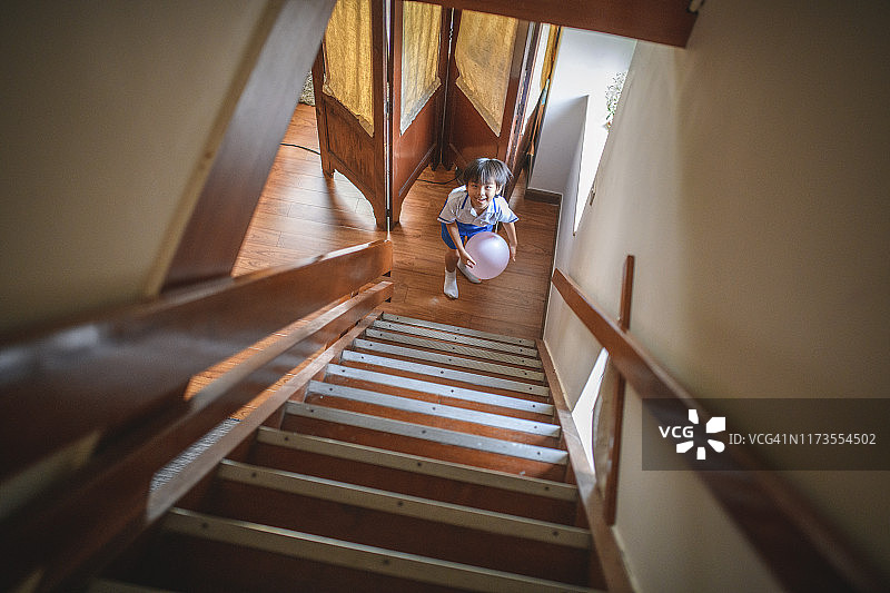 在楼梯底部玩气球的中国男孩图片素材