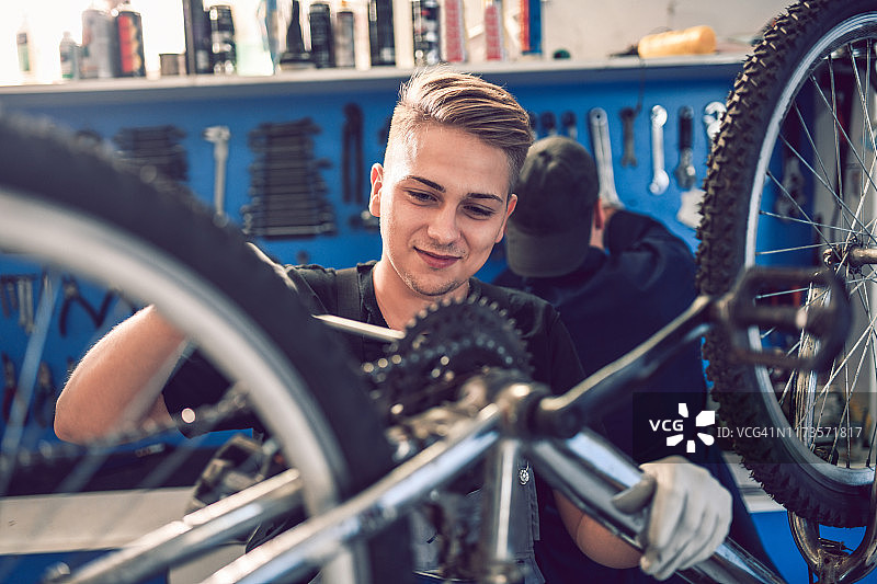 学徒修理工正在修理自行车变速器图片素材