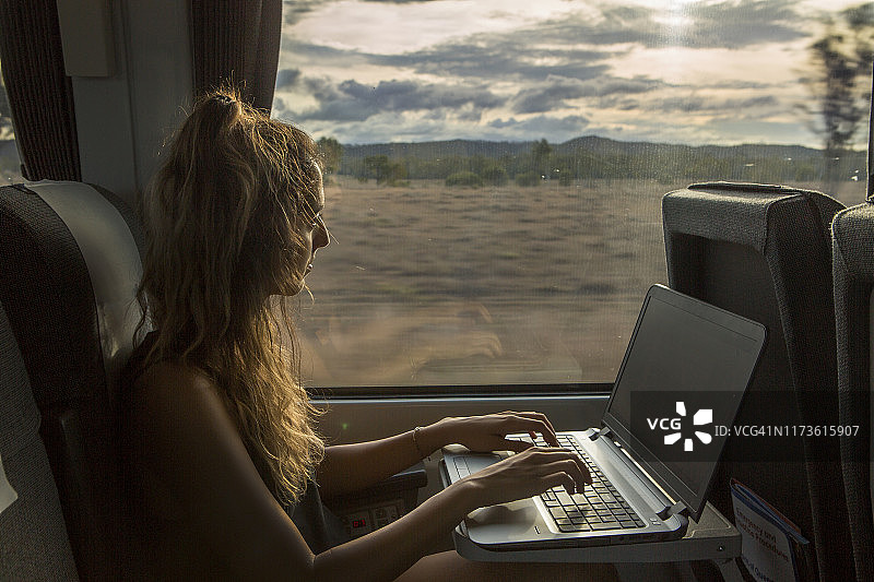女人在火车上用笔记本电脑工作图片素材