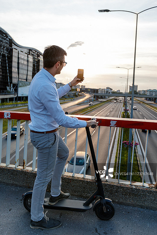 通勤者骑电动滑板车，日落高速图片素材