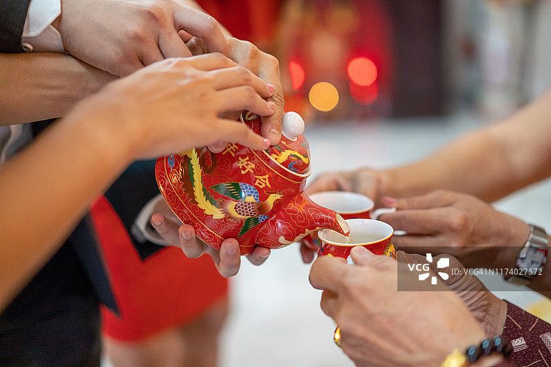 新婚夫妇在传统中式敬茶仪式上为长辈敬茶图片素材