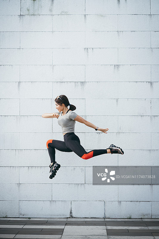 自信活力年轻运动女人公园跳跃图片素材