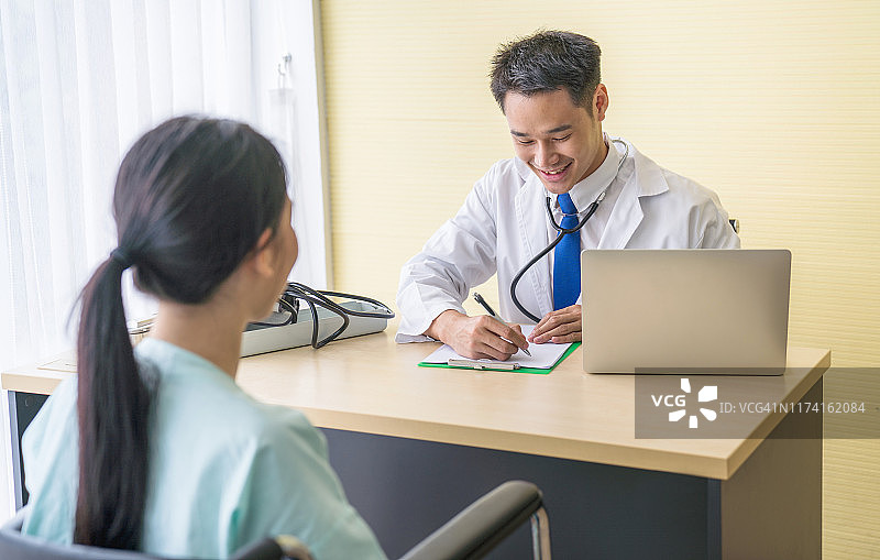 医生咨询男病人，诊断男性疾病或精神疾病，并在诊所或医院办公室的处方记录单上书写信息图片素材