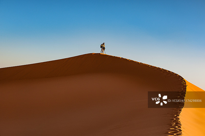 男游客在北非摩洛哥切比沙丘下午拍照图片素材