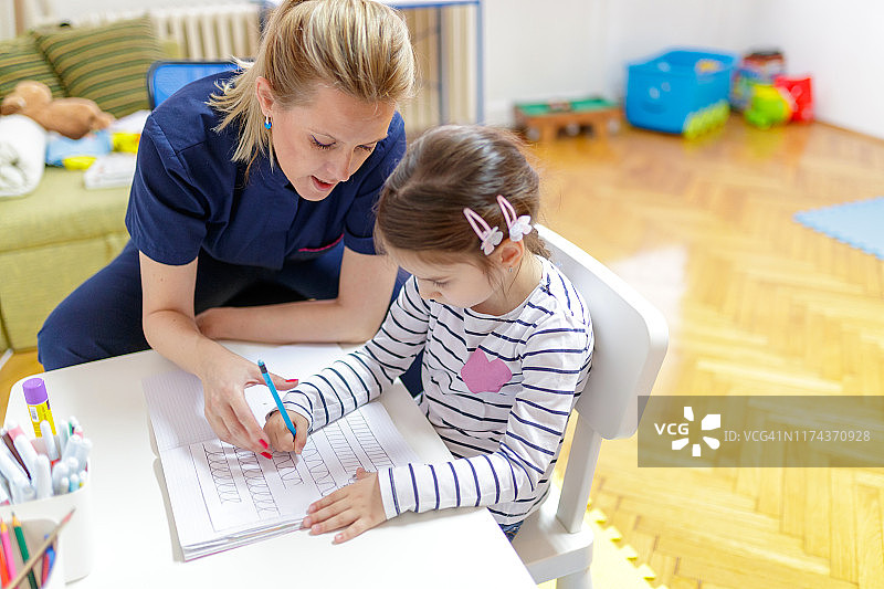 女孩在练习本上描摹图片素材