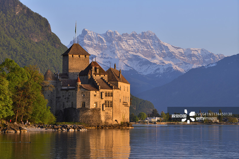 夕阳下的西庸城堡，位于日内瓦湖畔，背景是米迪山图片素材