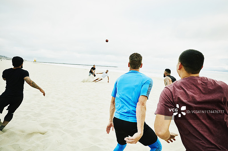 在海滩比赛中，足球运动员们正在等待传球图片素材