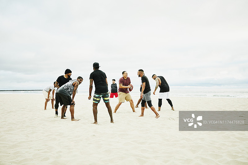 在沙滩足球比赛中准备玩耍的微笑欢笑的朋友图片素材