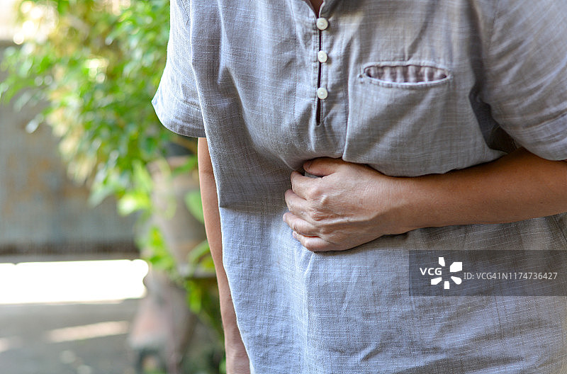 因腹痛而捂住腹部的妇女图片素材