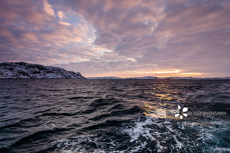 日落时分在渔船上眺望暴风雨中的巴伦支海图片素材