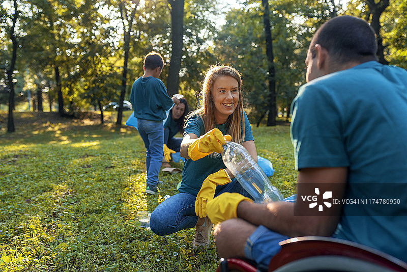 年轻漂亮女人自愿清理公园图片素材