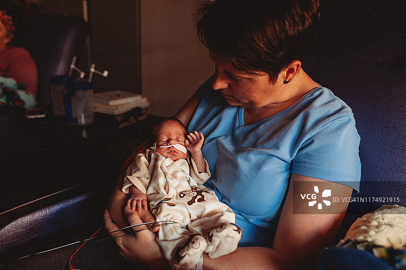 在新生儿重症监护病房，母亲抱着29周早产儿图片素材