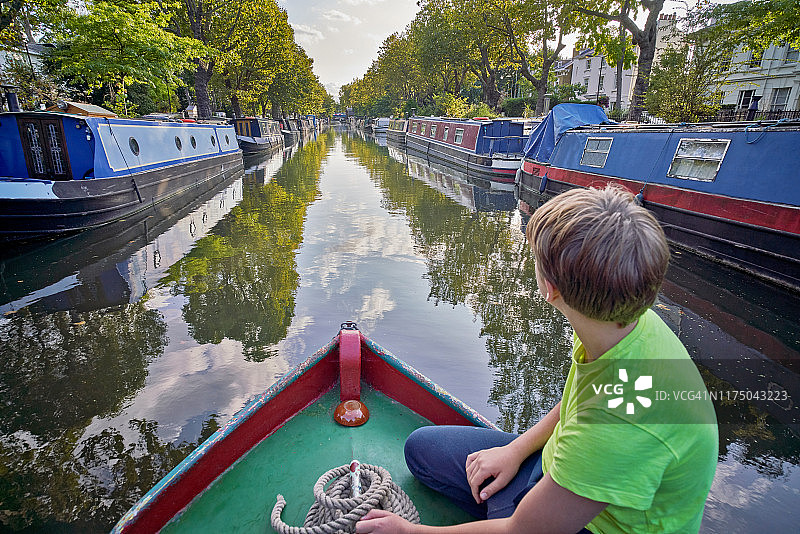 小男孩在狭窄的船头守望图片素材