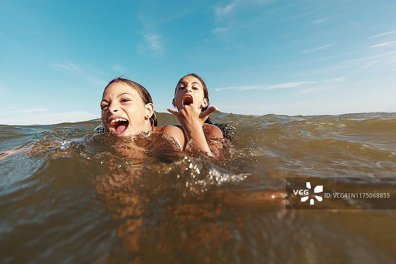 两姐妹在巴西东北部阿拉戈斯州石头港海滩快乐地玩水图片素材
