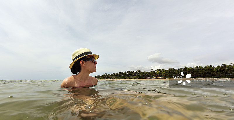 戴着草帽的女人在巴西阿拉戈斯州佩德拉斯港海滩享受退潮图片素材