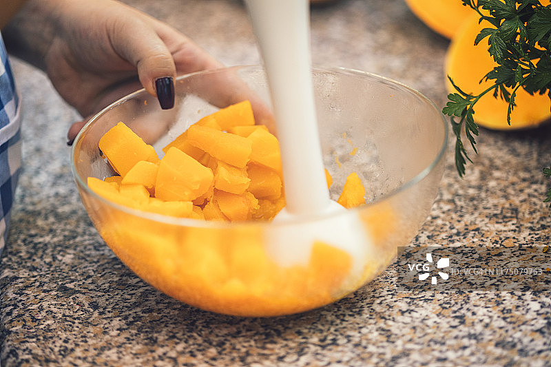 年轻女子在家准备南瓜汤图片素材