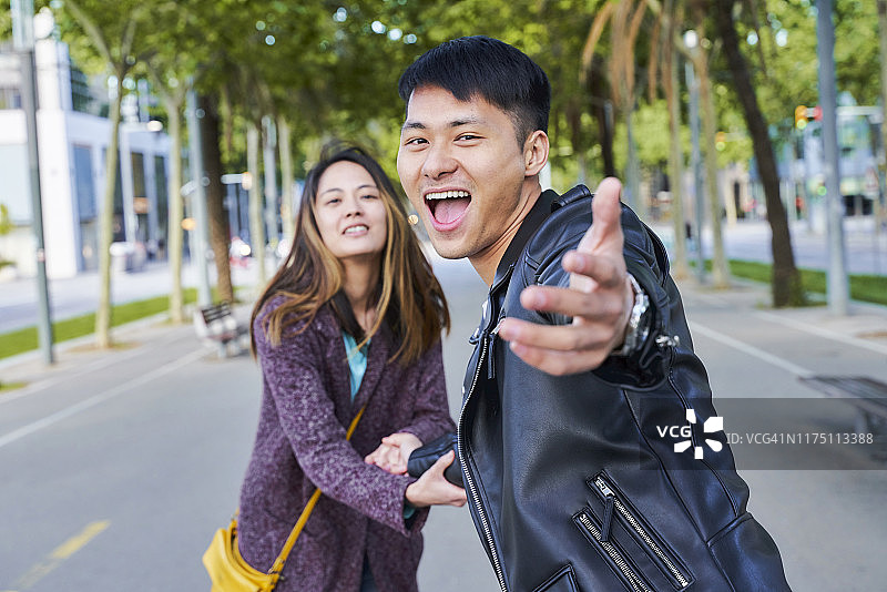 快乐的情侣邀请某人加入他们的巴塞罗那漫步图片素材