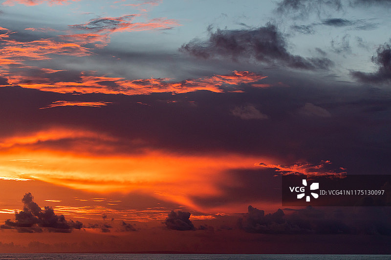 壮丽多彩的热带日落：红色、橙色、粉色的云彩，热带背景图片素材