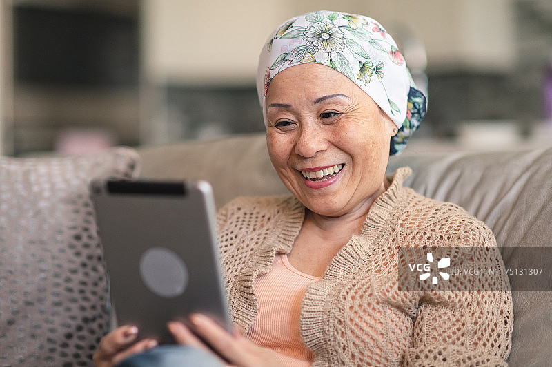 身患癌症的女人在平板电脑上与朋友进行视频聊天图片素材