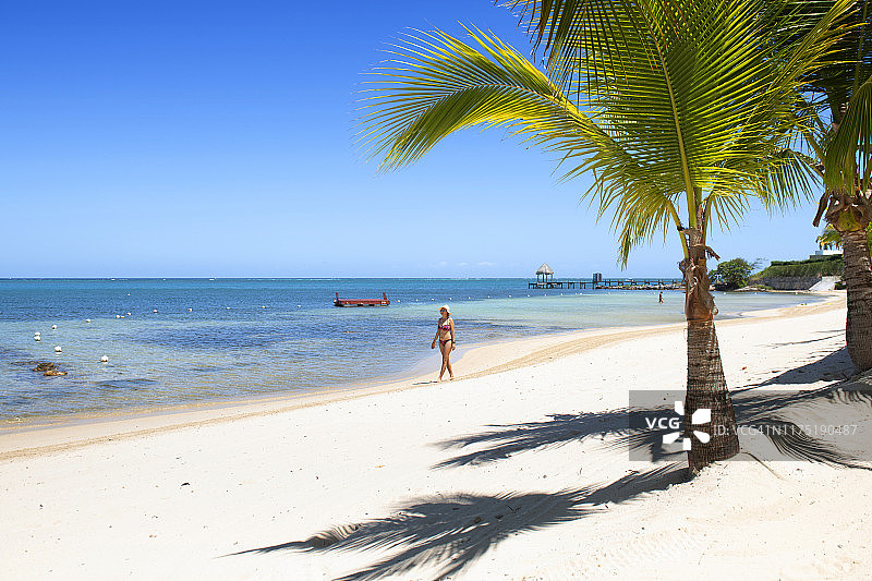 在远处海滩上行走的女人图片素材