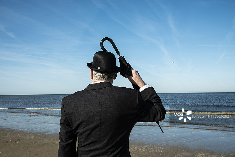 站在海滩上眺望大海的英国男人图片素材