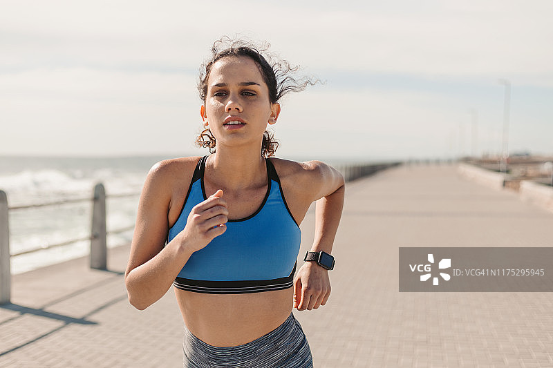 在海边慢跑的年轻女人图片素材