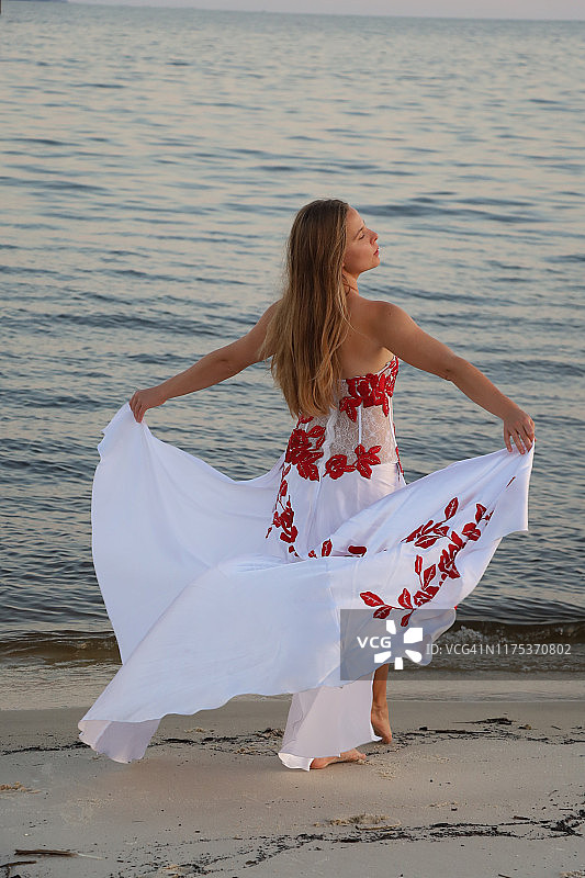 女士身穿白色长裙站在海滩上图片素材