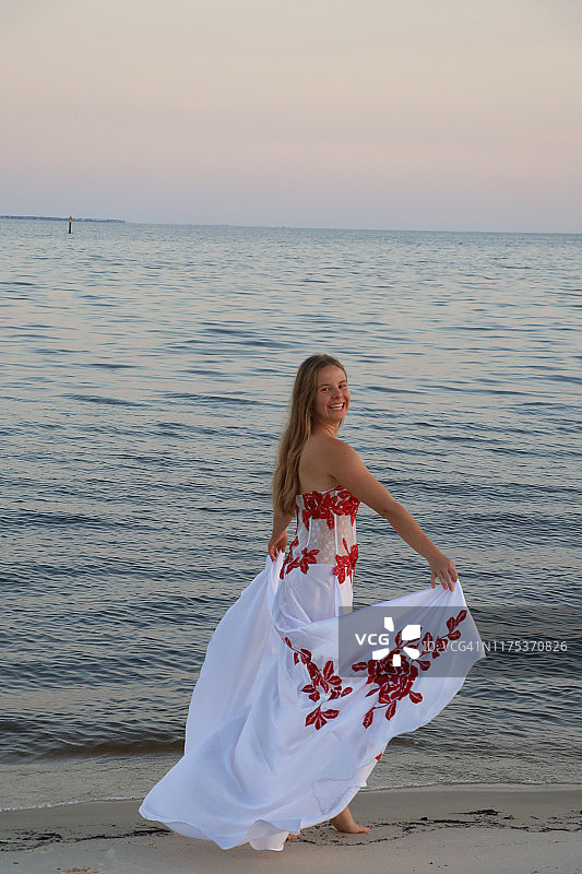 女士身穿白色长裙站在海滩上图片素材
