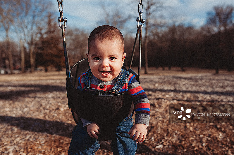 8个月大的异卵双胞胎宝宝在摇摆时大笑图片素材