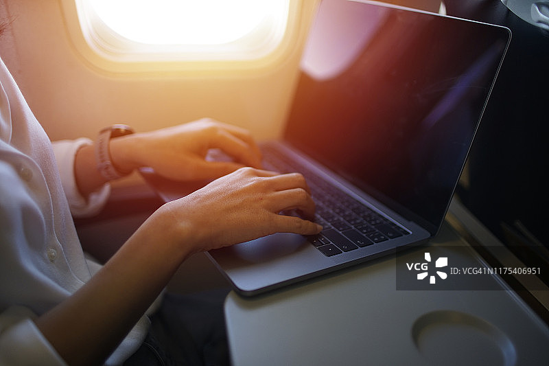 商务女性在航班上使用笔记本电脑工作图片素材