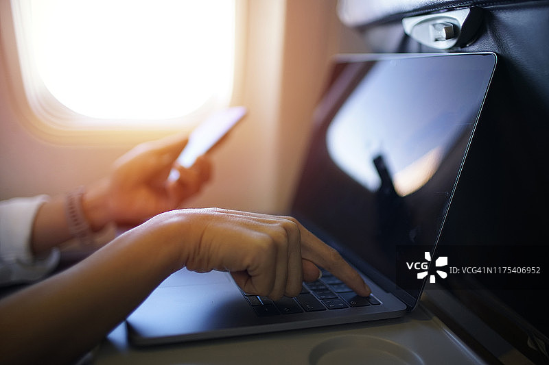 商务女性在航班上使用笔记本电脑工作图片素材