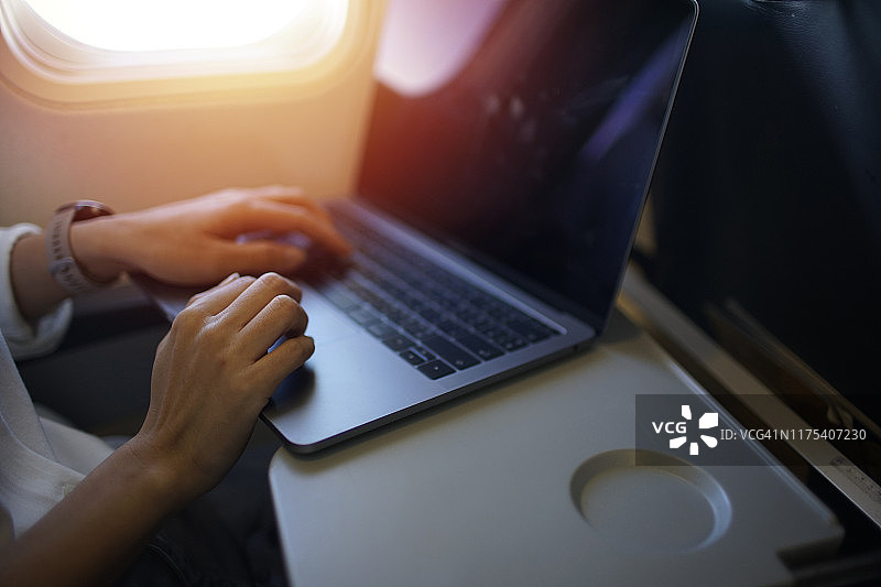 商务女性在航班上使用笔记本电脑工作图片素材