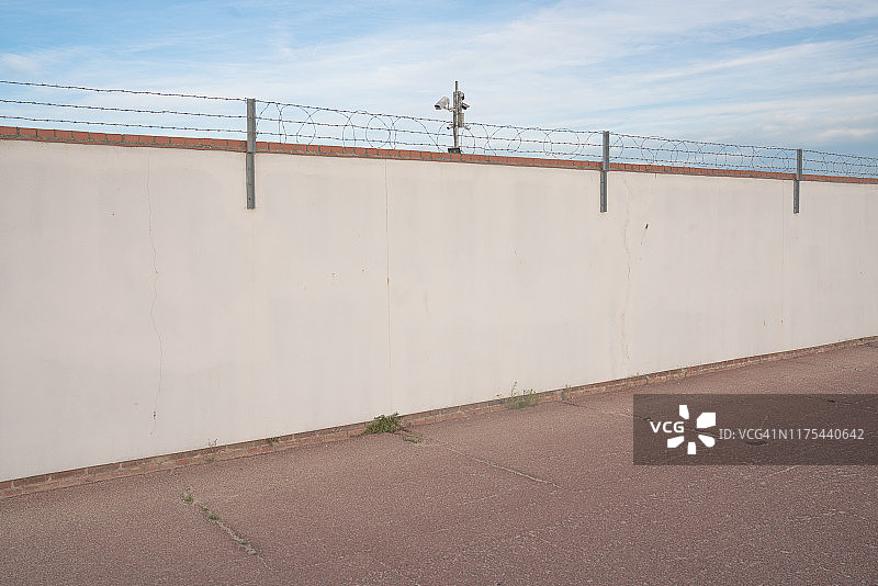 带刺铁丝网墙上的监控摄像头图片素材