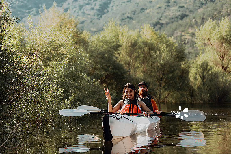 朋友们在皮划艇上休息，在加利福尼亚州卡维亚赫做出和平手势图片素材