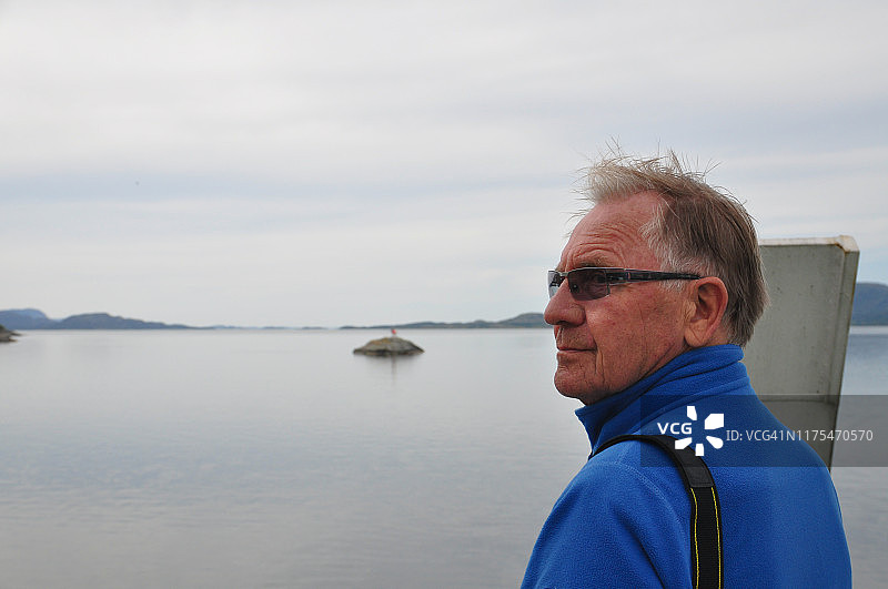 穿蓝色夹克的老年男人在渡轮上欣赏风景图片素材