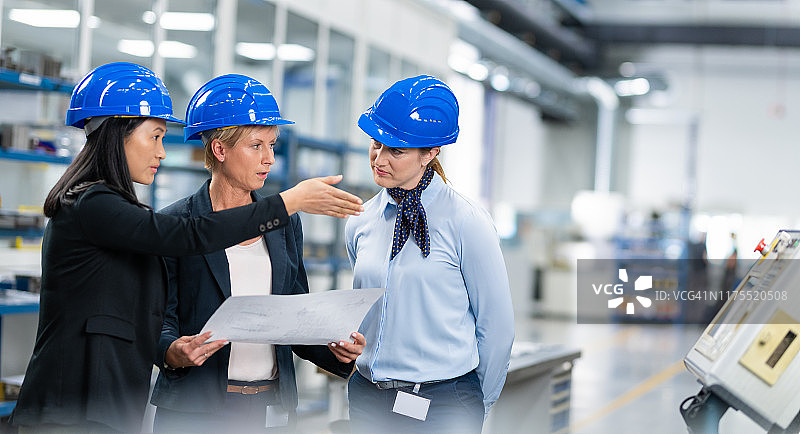 女工程师在工厂讨论蓝图图片素材