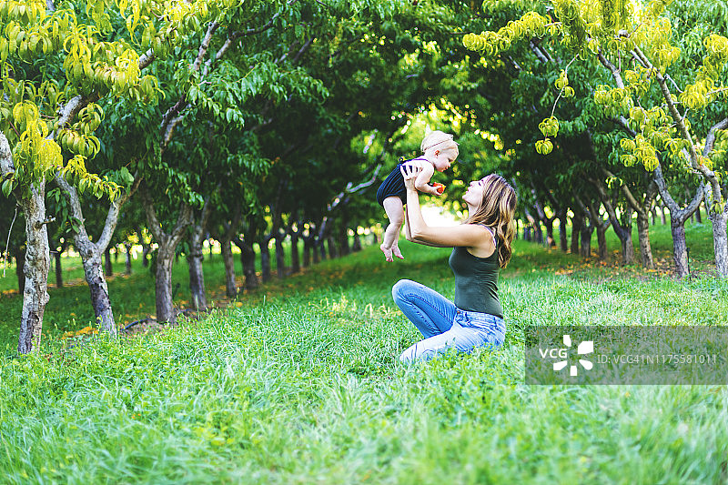 Y世代千禧一代年轻母亲和她年幼的女儿在科罗拉多州大章克申的桃园里图片素材