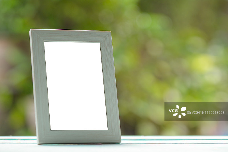 桌面上带有绿色模糊背景的相框图片素材