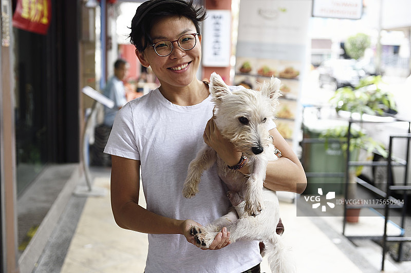 抱着她的狗的新加坡女人图片素材