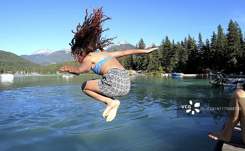 少女跳入冰冷的山间湖泊图片素材