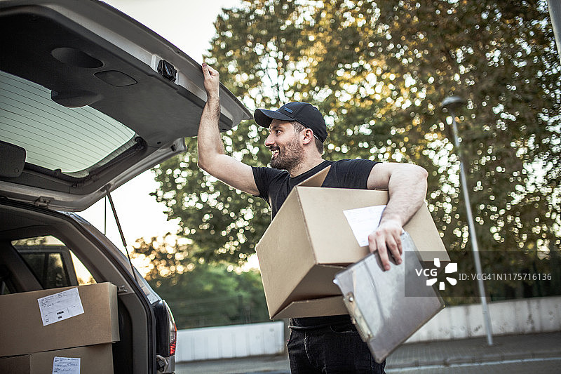 在街上手捧纸箱的送货员图片素材