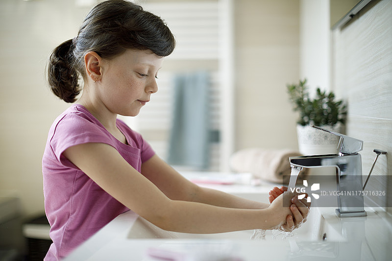在浴室洗手的可爱小女孩图片素材